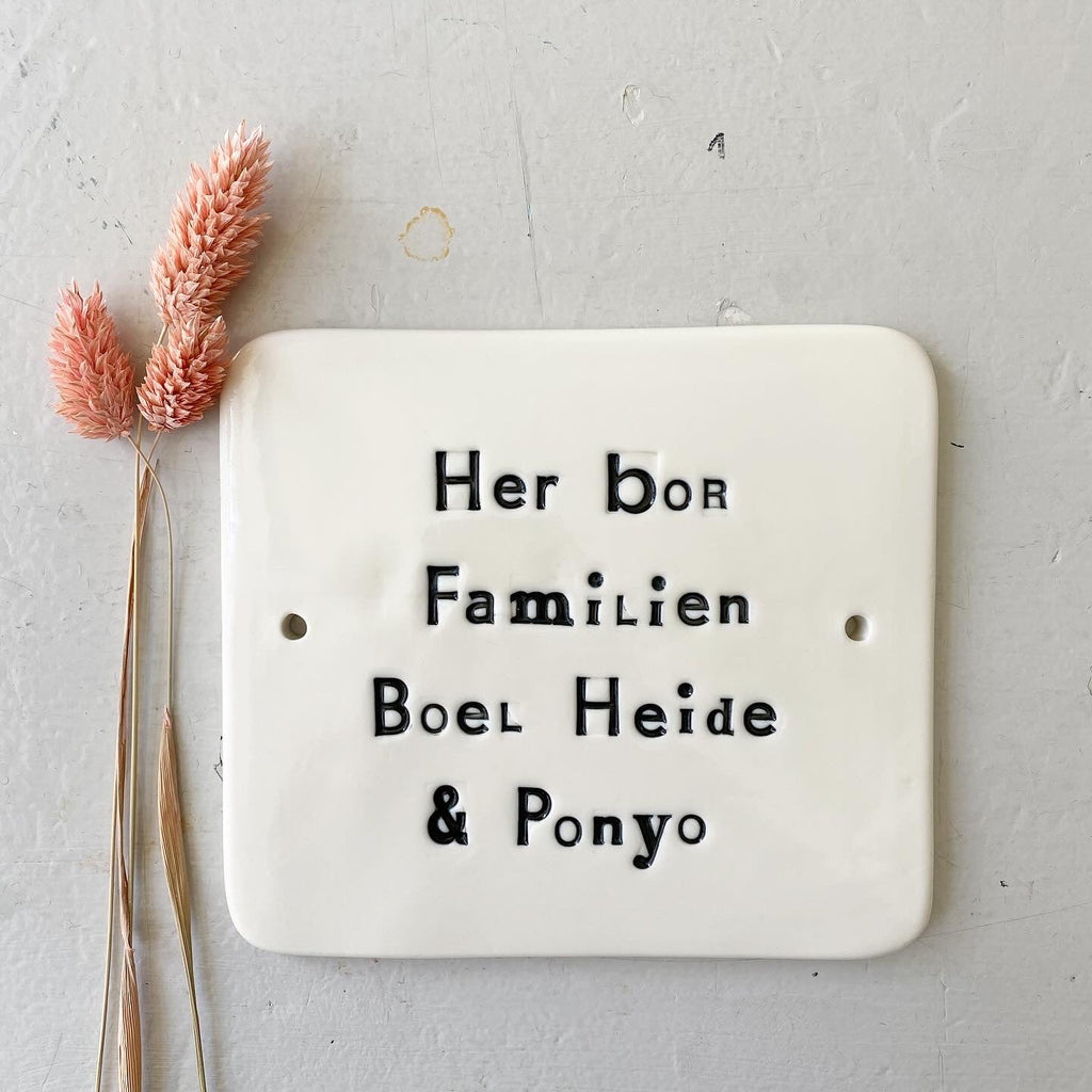 Dørskilt - med "her bor familien"