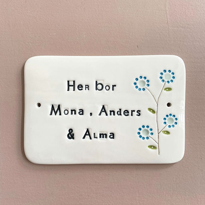 Dørskilt - med "her bor" og en blomst